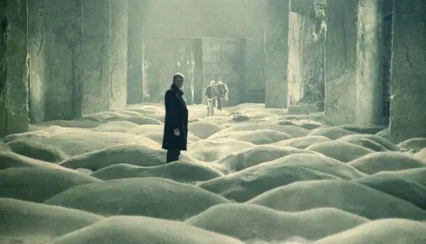 A scene from Stalker in a vast room covered by sand dunes