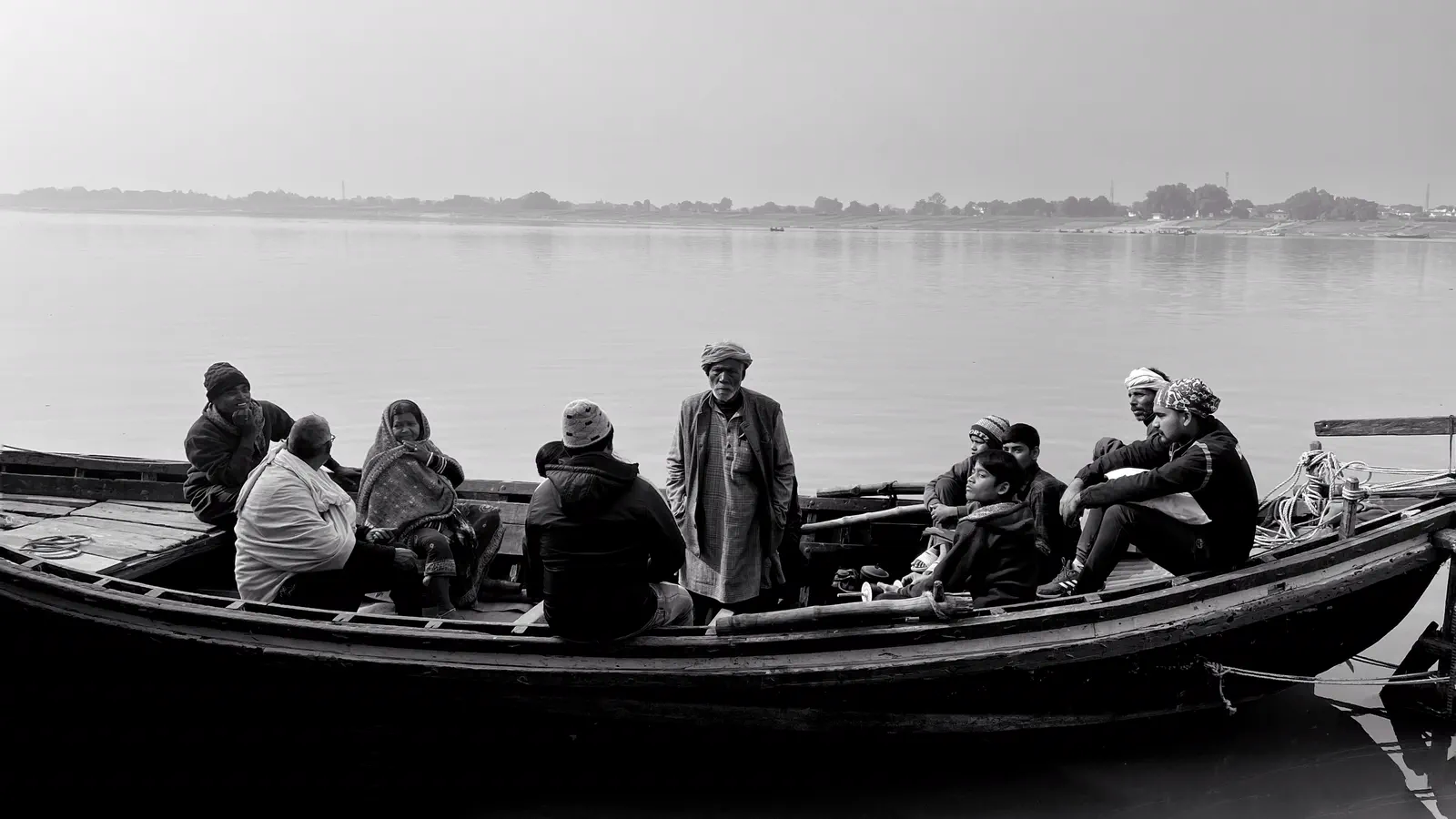 People gathered in a wooden boat on calm water